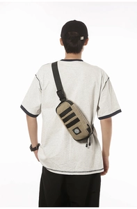 Tactical khaki chest bag with adjustable black strap shown from the back perspective