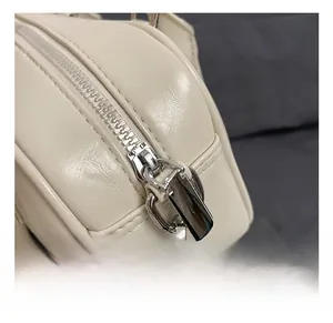 Détails de la fermeture éclair argentée et boucle sur sac bowling crème