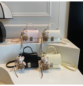 Detailed view of casual crossbody bags in four colors with cute bear charms on display