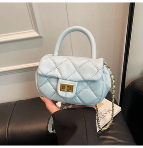 Dettaglio mini borsa trapuntata azzurra con chiusura a scatto dorata e tracolla a catena