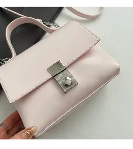 Close-up of pink faux leather handbag with brushed silver rectangular metal buckle