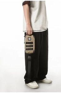 Close-up of khaki tactical chest bag with black MOLLE webbing and circular embroidery