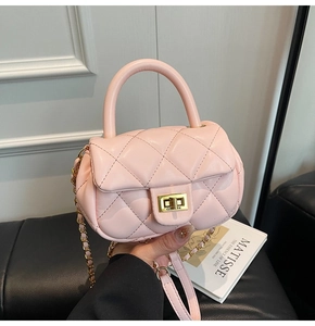 Dettaglio ravvicinato di una mini borsa rosa trapuntata con chiusura a scatto oro