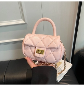 Dettaglio della mini borsa trapuntata rosa con chiusura dorata e tracolla a catena