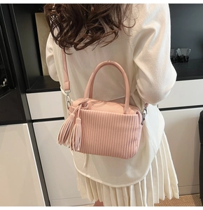 Pink lychee texture crossbody bag with elegant fringe detail shown on a model