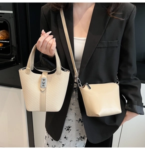 Detail of beige bucket bag with woven texture and matching leather crossbody bag set