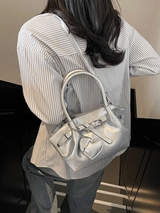 Bolso tipo cubo plateado metalizado con amuleto de corazón y detalle de hebilla de moda