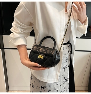 Dettaglio mini borsa nera a trapunta con chiusura a scatto dorata e tracolla