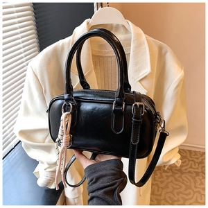 Detailaufnahme der schwarzen matten PU-Boston-Tasche mit silbernen Beschlägen und Anhänger