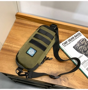Detail view of olive green tactical chest bag with MOLE webbing on a wooden desk