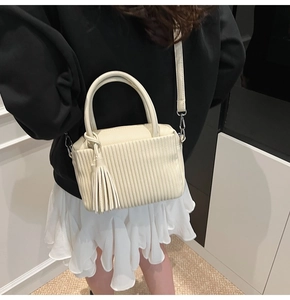 Detailed back view of cream mini crossbody bag with vertical pleats and long tassels