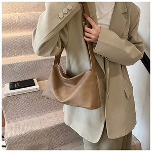 Détail d'un sac bandoulière en similicuir marron avec large sangle et zip métallique