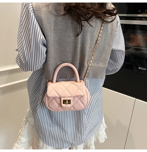 Borsa a tracolla trapuntata rosa con chiusura a rotazione dorata indossata da una modella