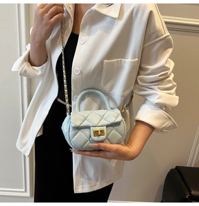 Dettaglio mini borsa trapuntata celeste con chiusura a rotazione dorata e catena