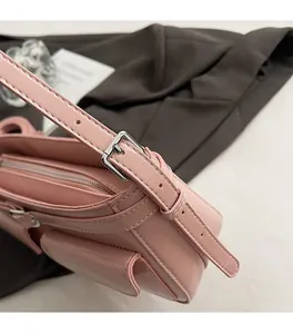 Détail du sac à bandoulière rose clair avec boucle argentée et coutures précises