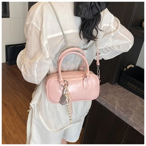 Detail der rosa Lackleder Boston Tasche mit Metallic-Finish und Blattanhänger am Gurt
