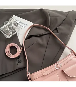 Détail du sac sous l'aisselle en cuir PU rose avec boucle argentée sur blazer gris