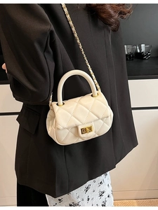 Borsa a tracolla beige trapuntata con catena e chiusura a girello dorata indossata da modella