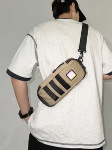 Khaki outdoor cylindrical chest bag with reflective logo on a male model back