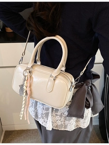 Crème Vintage Boston Tasche mit Tragegriffen und Fischanhänger getragen am Modell