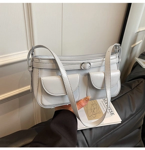Détail du sac épaule gris clair brillant avec deux poches et boucle anneau argentée