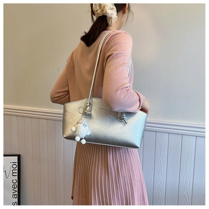 Detail of silver metallic shoulder bag with crinkled texture and white plush charm