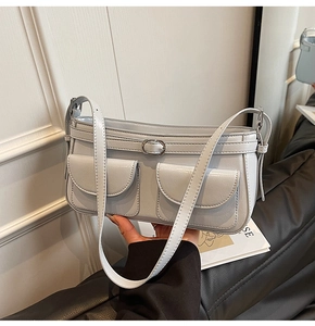 Détail du sac bandoulière en similicuir bleu clair avec deux poches avant et boucles