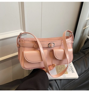 Détail du sac à main rose en cuir brillant avec poches avant et boucles métalliques