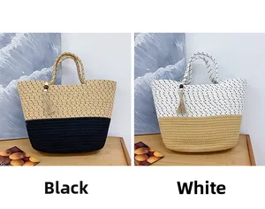 Detail of woven straw beach bags with tassels in black and white contrasting colors