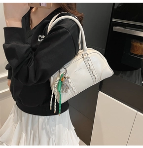 Vue détaillée du sac à main blanc en simili cuir avec texture tressée et pendentif ours