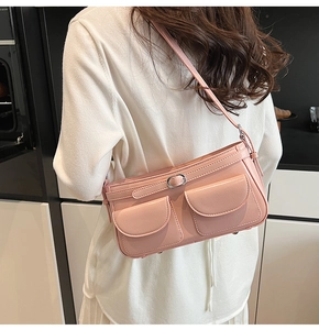 Détail du sac porté épaule rose clair avec doubles poches et boucles métalliques