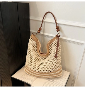 Detail of woven boho handbag featuring intricate hollow mesh patterns and wooden bead accents