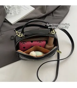 Vue de dessus de l'intérieur spacieux du sac rond noir matelassé avec fermeture éclair