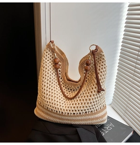 Detailed close-up of woven shoulder bag featuring wooden bead straps and hollow mesh texture