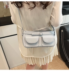 Détail du sac bandoulière bleu clair avec poches cargo et pieds de protection