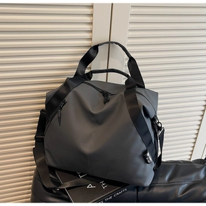 Detail of grey travel tote bag showing water-resistant fabric and adjustable shoulder strap