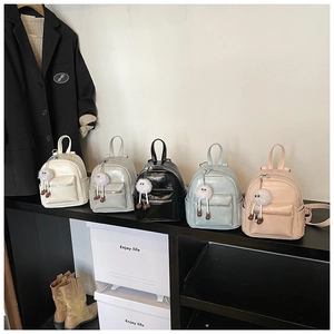 Detailed view of trendy mini backpacks in five colors with cute plush doll charms