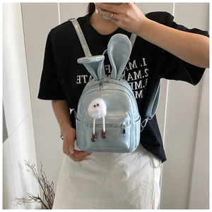 Detail view of light blue glossy backpack featuring cute 3D bunny ears and plush pendant
