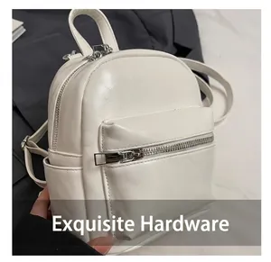 Detail shot of white mini backpack showing lychee grain PU leather and silver hardware