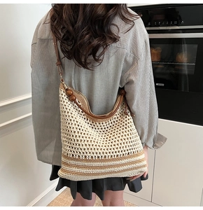 Close-up of hollow woven shoulder bag with brown stripes and wooden bead details