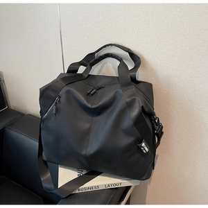 Macro shot of large black travel bag on leather sofa with adjustable shoulder straps
