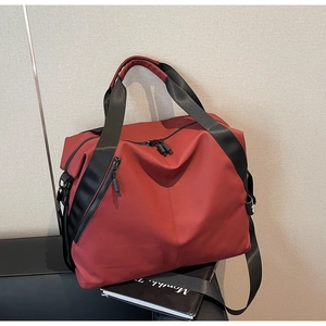 Close-up of dark red waterproof travel bag with durable nylon texture and side buckle