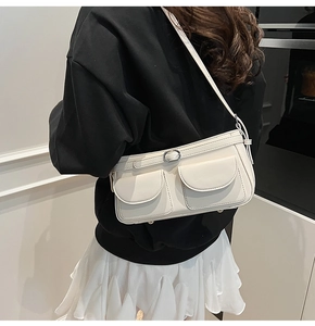 Vue détaillée de profil d'un sac porté épaule minimaliste crème à deux poches avant