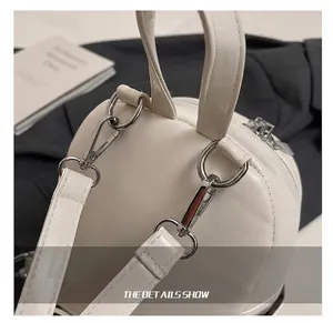 Close-up of white leather backpack with silver hardware, swivel hooks and precision stitching
