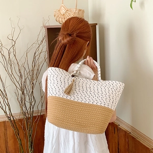 Detail of woven beach tote showing dual-tone texture and stylish tassel decoration