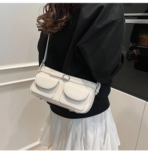 Détail du sac à épaule blanc crème en similicuir avec doubles poches et boucles argent