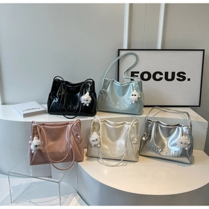 Detail of colorful soft leather tote bags with brand logos and sheep pendants