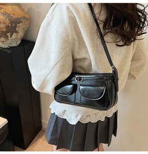 Gros plan du sac porté épaule en cuir verni noir avec détails de poches style Y2K