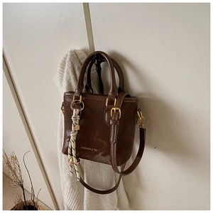 Detail of dark brown tote bag with striped scarf and gold Fashion & YM logo lettering