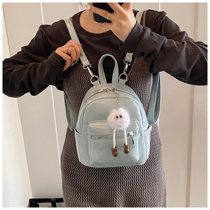 Detail shot of mint blue PU leather backpack with a cute plush doll charm